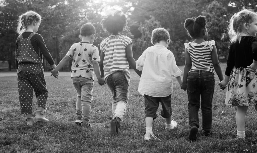 Black and white photo of children holding hands