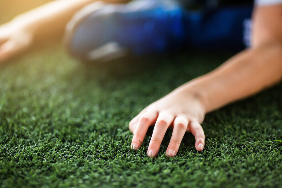 Child's hand on artificial turf