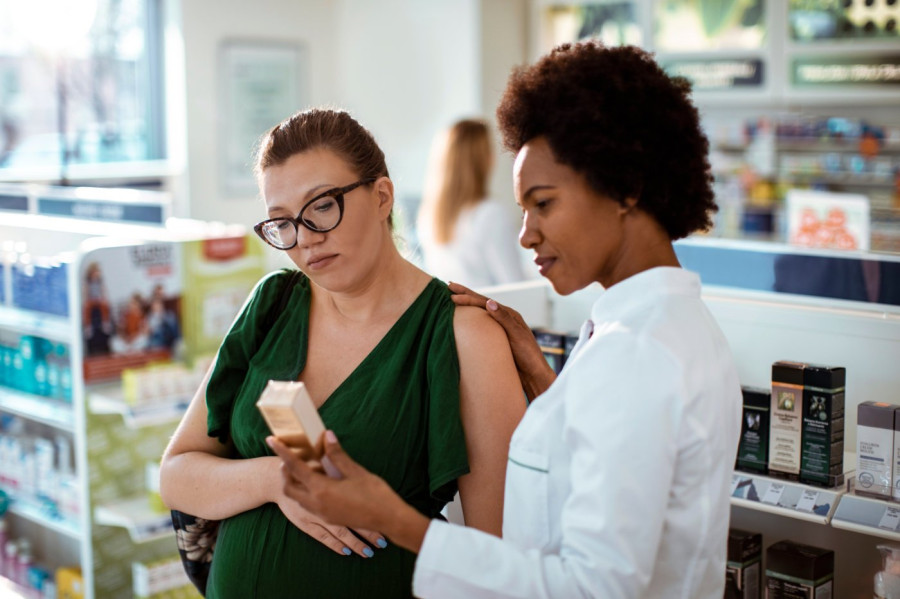 Pregnant woman discussing product ingedients with pharmacist