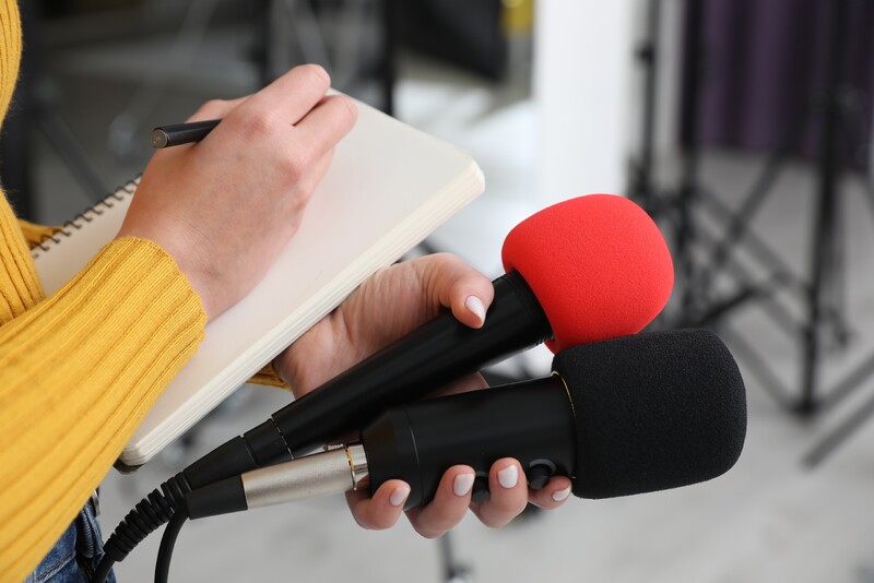 journalist taking notes with two microphones