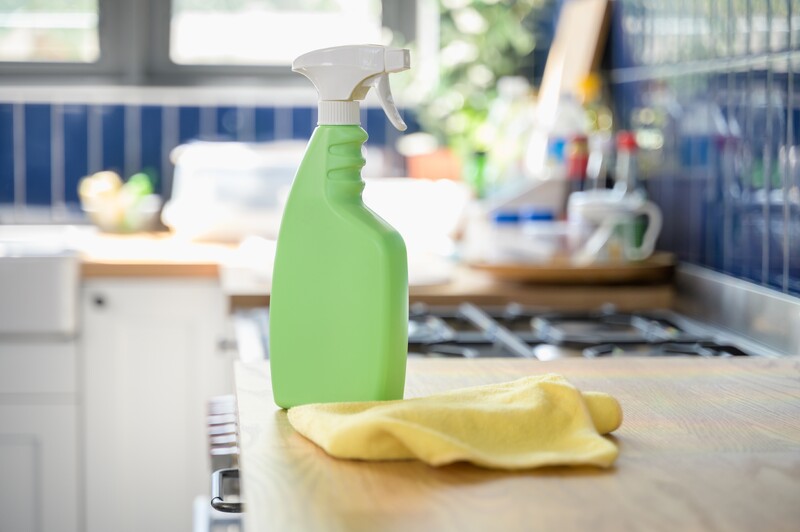 green cleaning spray bottle and yellow cloth
